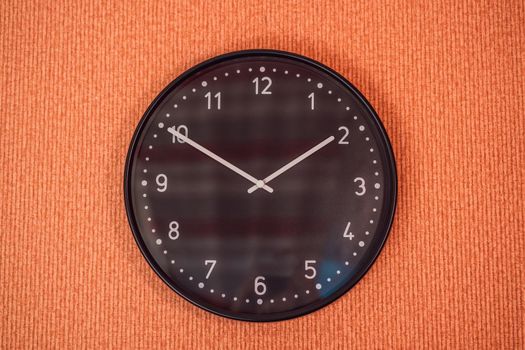 Classic black and white analog clock on red background at One o'clock with copy space