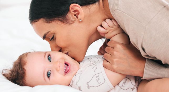 Mom gives the sweetest kisses. a woman bonding with her adorable baby boy at home.
