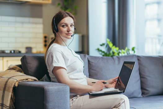 Pregnant woman working remotely at home, using video call headset, consultant sitting
