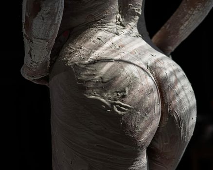 Female naked butt covered with plaster like a statue.