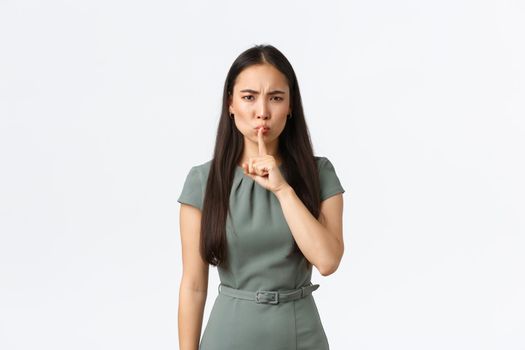 Small business owners, women entrepreneurs concept. Strict serious-looking hushing, say shh and press index finger to lips, telling stay quiet, demand silence or hold mouth shut, white background