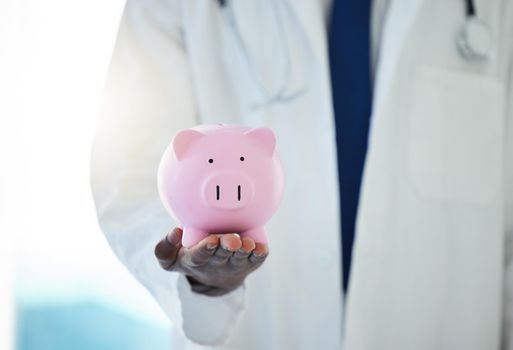 Protect your health at all costs. an unrecognisable doctor holding a piggybank.