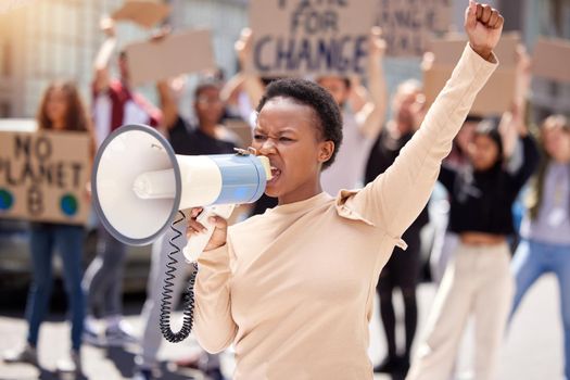 Give us what we want. a young woman shouting through a loudhailer at a protest.