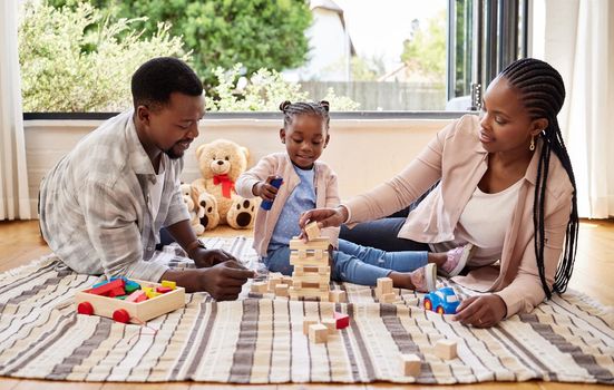Relationships are nothing without a solid foundation. a little girl playing with blocks with her parents at home.