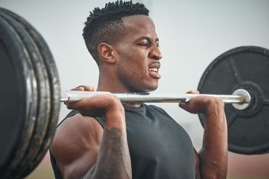 Train hard so you can stay strong. a muscular young man exercising with a barbell outdoors.