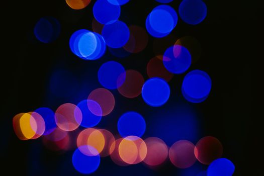 Unfocused abstract background. Bokeh garlands with yellow and blue lights.