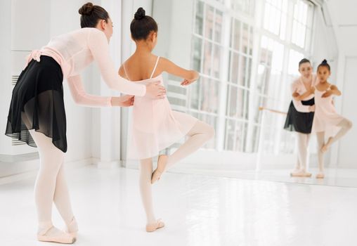 Lift those knees. a little girl practicing ballet with her teacher in a dance studio.