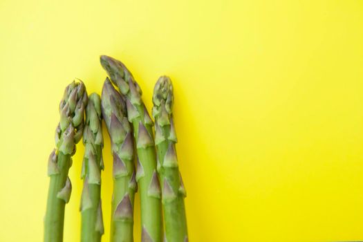 Fresh asparagus on yellow background