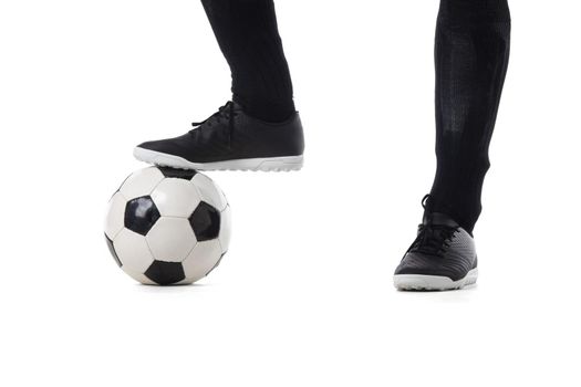 Legs of soccer player close-up and ball isolated on white background