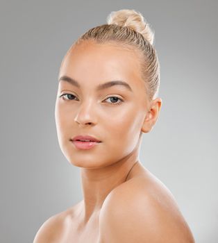 Glowing skin is a result of proper skin care. an attractive young woman posing against a studio background.