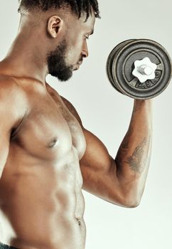 More lifting, more muscle. a muscular young man lifting dumbbells.