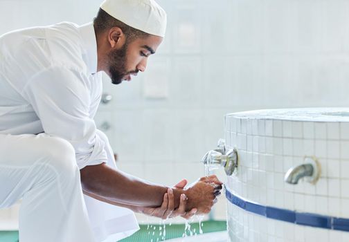 Preparations for prayer time. a young man washing his hand in a mosque.