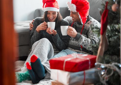 I wouldnt spend Christmas any other way. a young couple drinking coffee while celebrating Christmas at home.