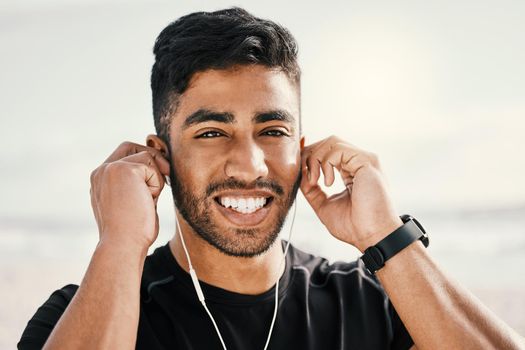 Music makes every workout better. a sporty young man wearing earphones while out for a workout.