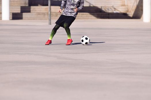 footballer playing the ball in a concrete court