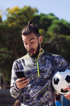 surprised sportsman consulting his phone
