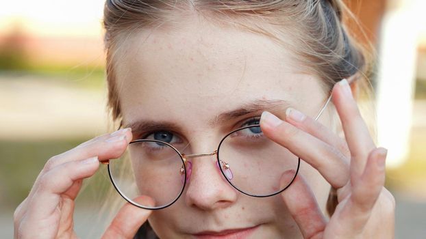 A teenage girl wearing glasses. Close-up of her face.