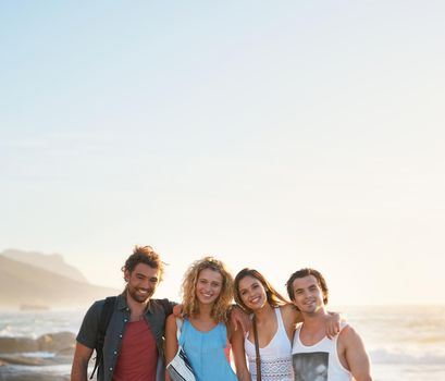 group of friends posing on beach having fun summer vacation lifestyle on seaside at sunset