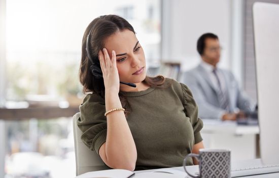 Dont let angry customers throw you off. a young call centre agent looking stressed out while working in an office.