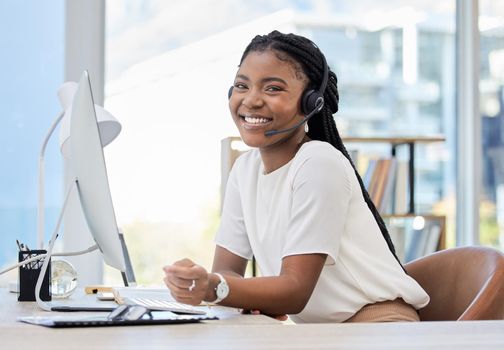 Always providing service with a smile. a young female call center agent using a computer at work.