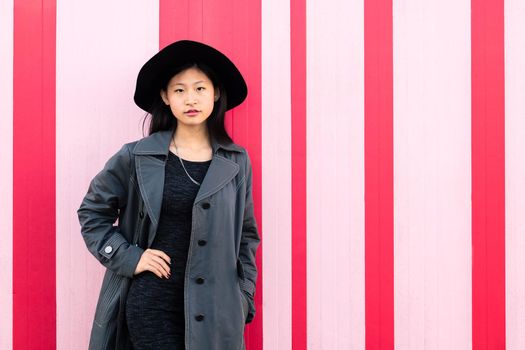 young classy asian girl posing in pink background
