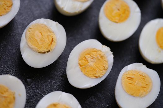 Sliced hard boiled eggs on dark background