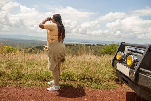 African American female guide using binoculars, looking for wildlife