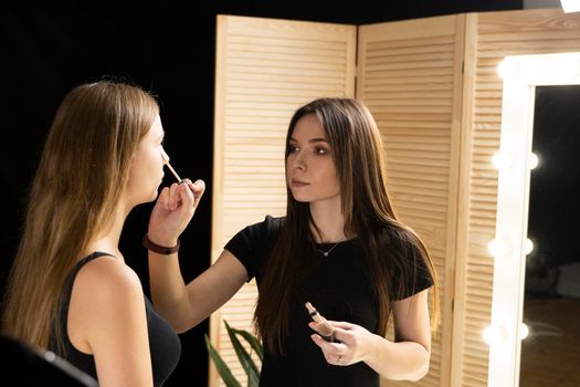 Proffesional makeup artist apply makeup to the beautiful model face. Beauty fashion model.