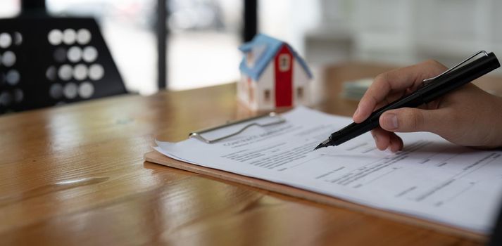 Real estate agent working sign agreement document contract for home loan insurance.