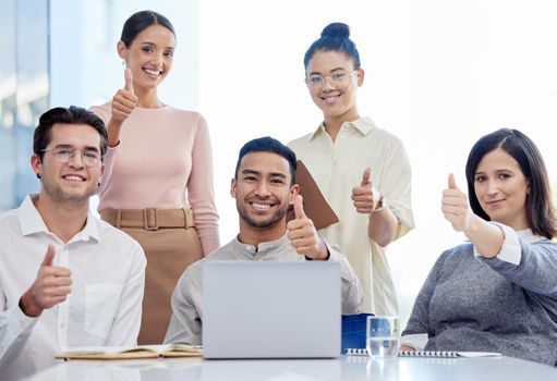 . Portrait of a group of businesspeople showing the thumbs up in a modern office.