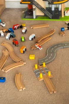 A scattered wooden road construction kit on the floor. Child's play