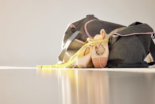 You cant put ballet into words. Thats why we dance. a pair on ballet shoes and a bag in a dance studio.