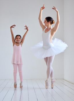 Dancing is like dreaming with your feet. a little girl practicing ballet with her teacher in a dance studio.