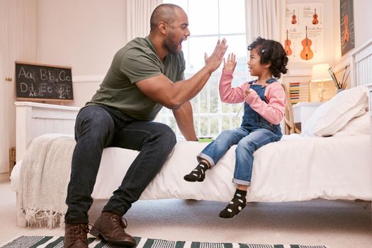 You deserve a high five. a young father and daughter giving each other a high five at home.