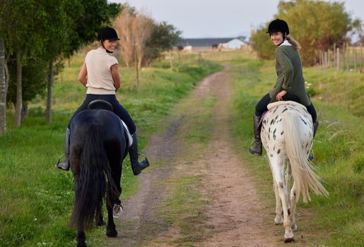 A horse is an adult treasure. two young women riding their horses outside on a field.