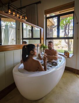 Men and women in a bath thub, couple on safari in South Africa at a luxuri safari lodge