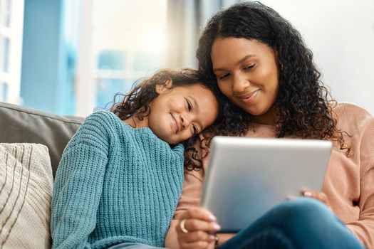 Ok, you choose. an attractive young woman sitting and bonding with her daughter while using a digital tablet.