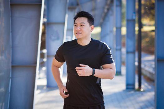 Asian athlete on a morning jog near the stadium, successful male businessman