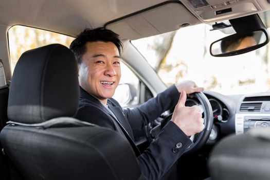 Successful businessman car salesman Male Asian driver behind the wheel