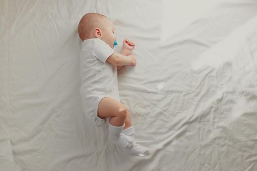 The baby is sleeping in his crib. Happy baby dream. A happy child. Children's article.
