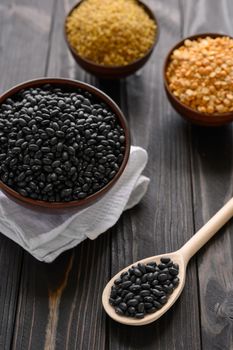 Different type of composition of raw dry legumes and cereals. Black beans, bulgur, peas.
