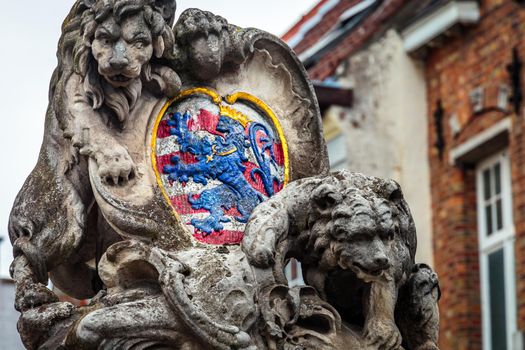 Lion and medieval stone empire shield in Bruges, Belgium