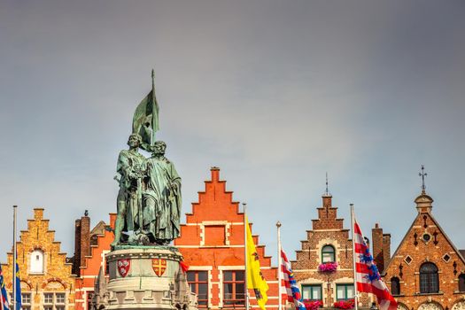 Bruges market square with flemish architecture and statue, Belgium