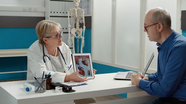 Female physician showing cardiology diagnosis on digital tablet