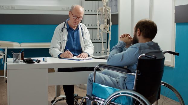 Health specialist doing consultation with wheelchair user
