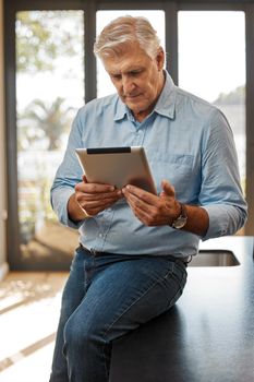 Always looking for the best properties. a senior male realtor using a digital tablet.