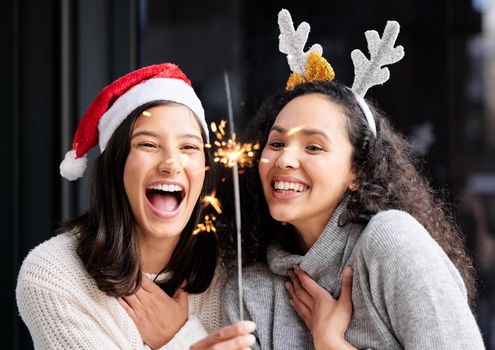 Christmas waves a magic wand over this world. two friends using a sparkle stick ay home.