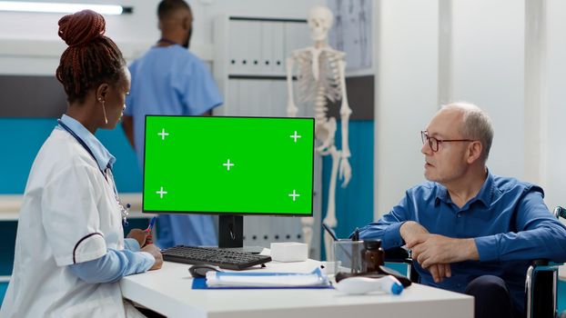 Doctor and patient with impairment using greenscreen on monitor
