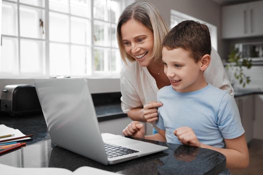 You scored the highest in your class. a mother and son team using a laptop to complete home schooling work.
