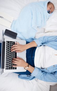 Work and home life balance. a mother using her laptop while her baby sleeps on the bed.